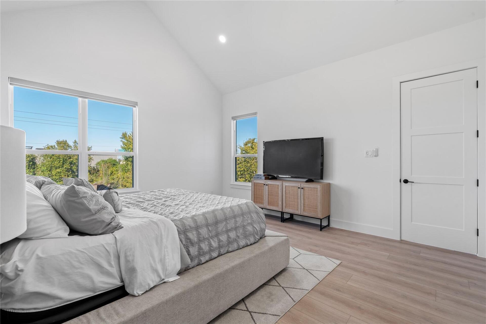 Angled ceiling lines and well-placed window openings give the bedroom a sense of volume and light, reinforcing a calm, airy atmosphere without visual clutter.