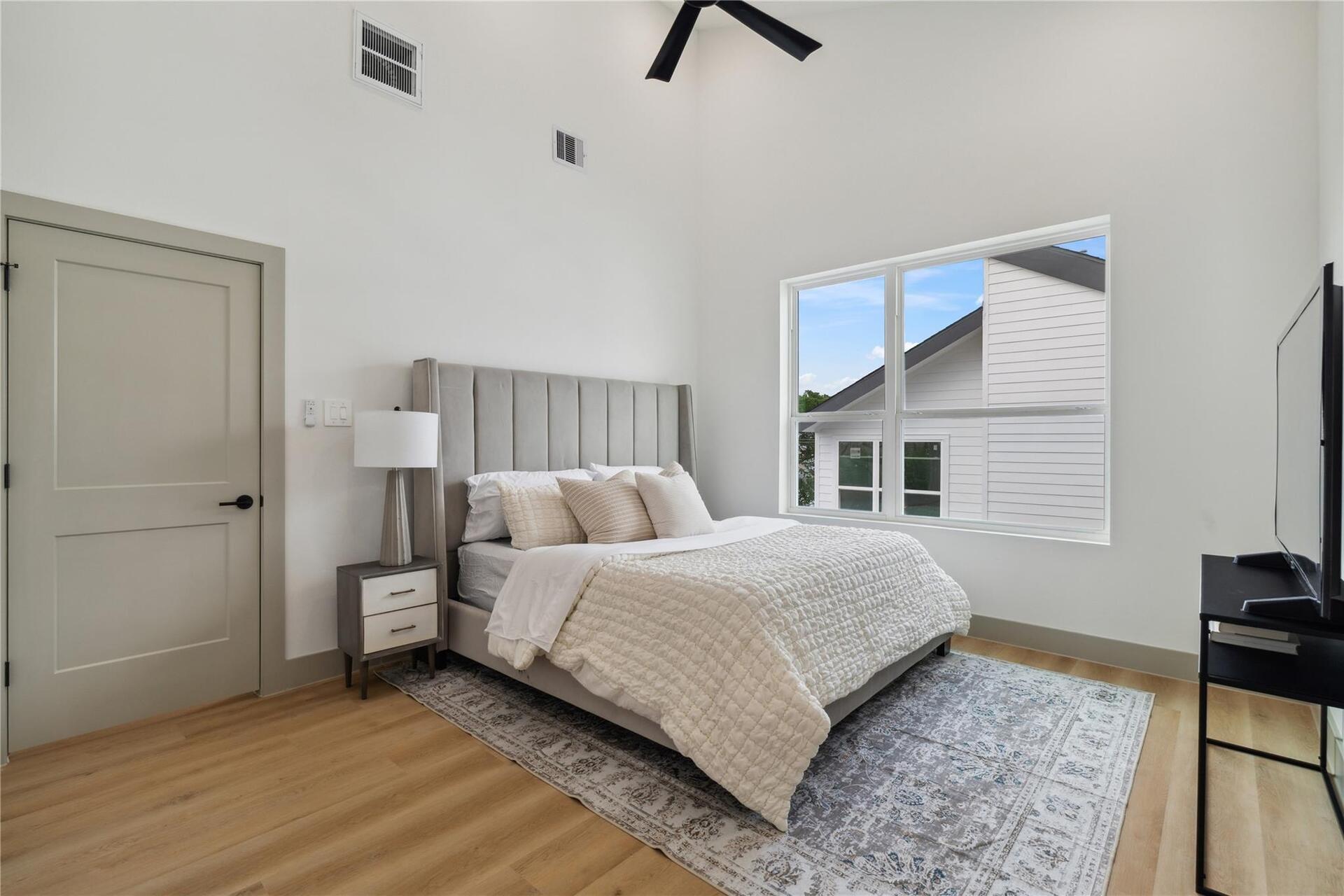 Vaulted ceilings with a modern fan overhead add volume and airiness, enhancing the sense of space and stillness.