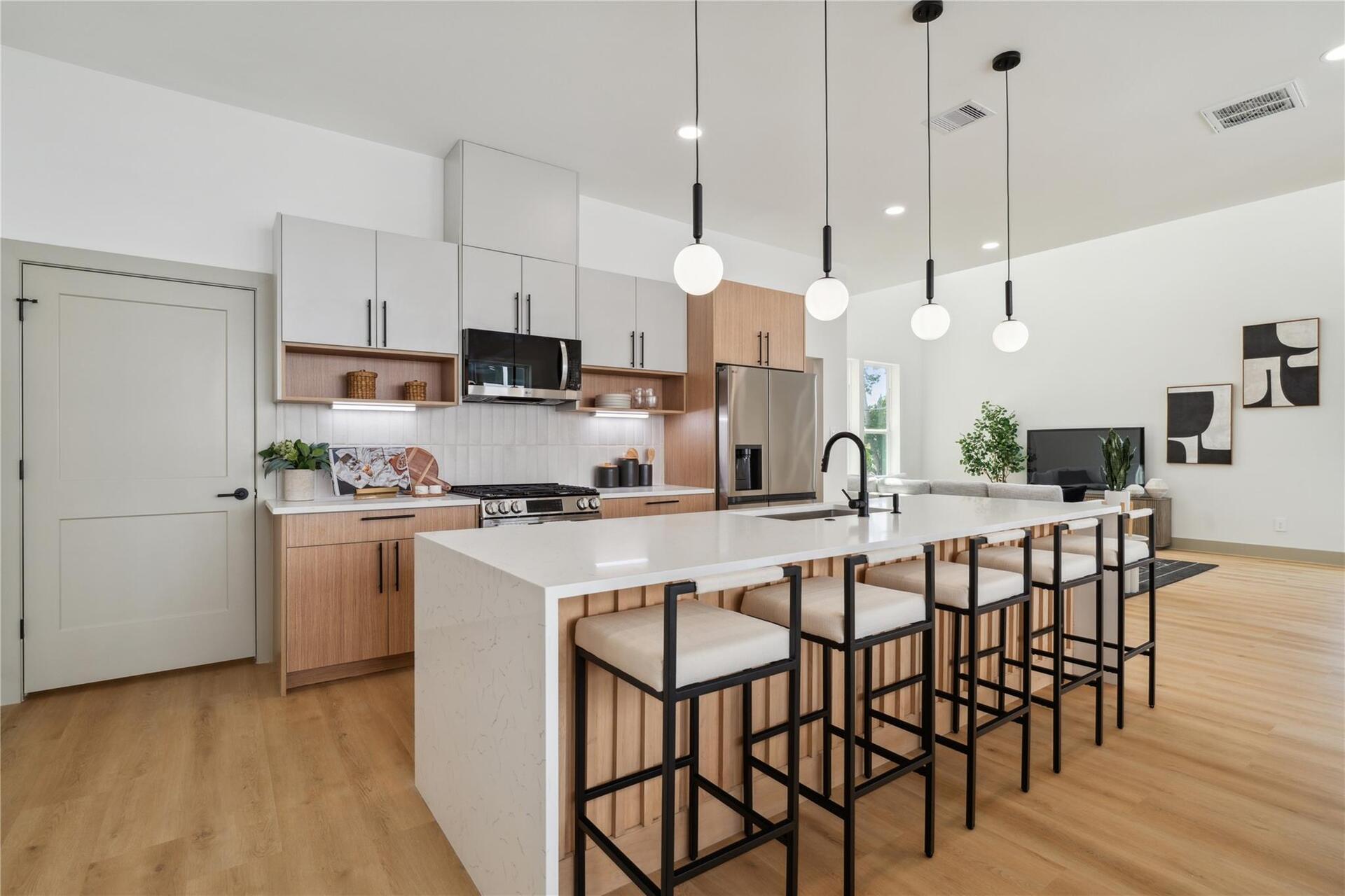 Matte black accents and globe pendants provide a refined contrast, complementing the soft, organic tones of the surrounding materials.