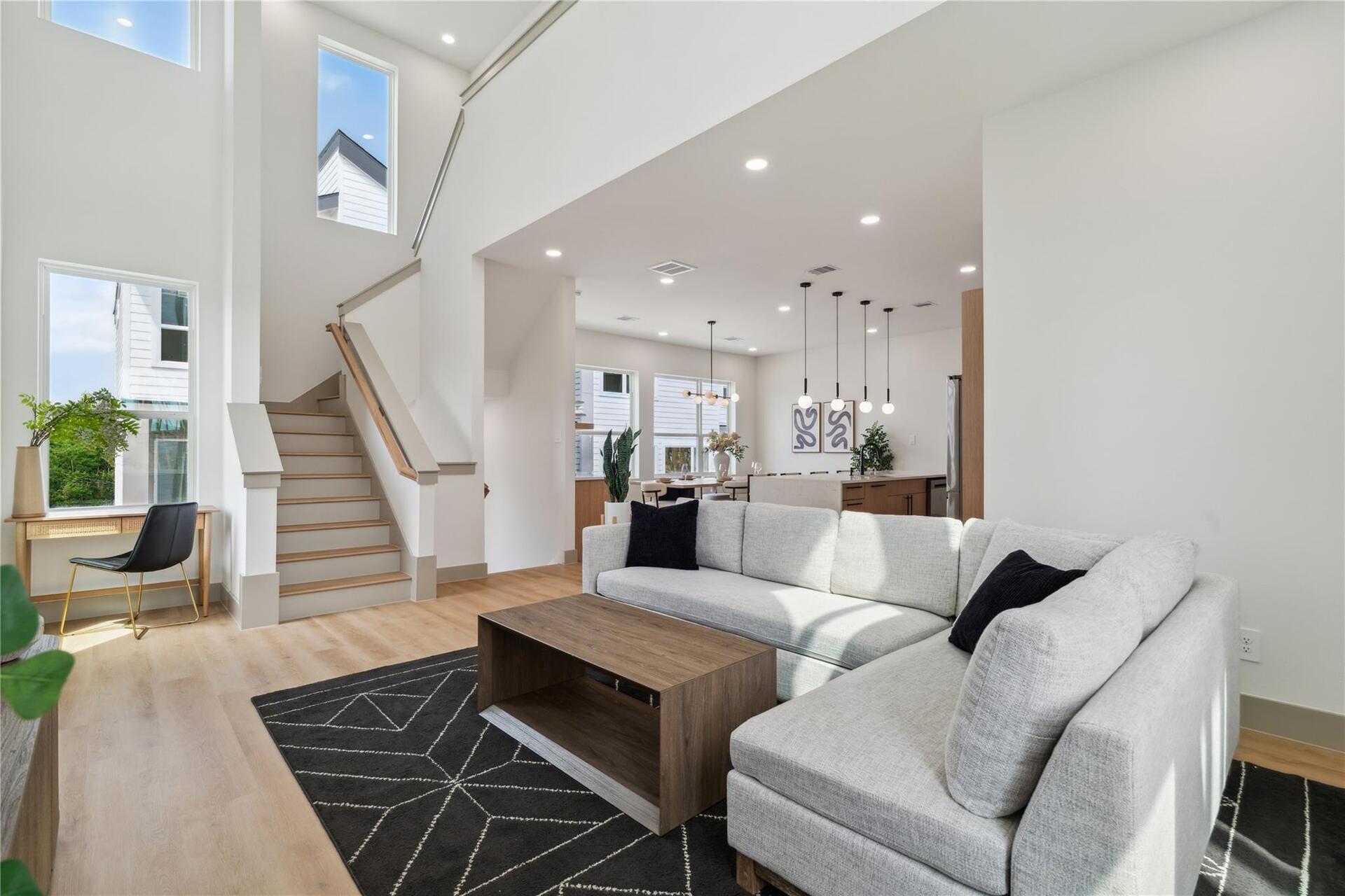 A masterclass in modern proportion—this living room balances vertical space with grounded textures and clean lines.