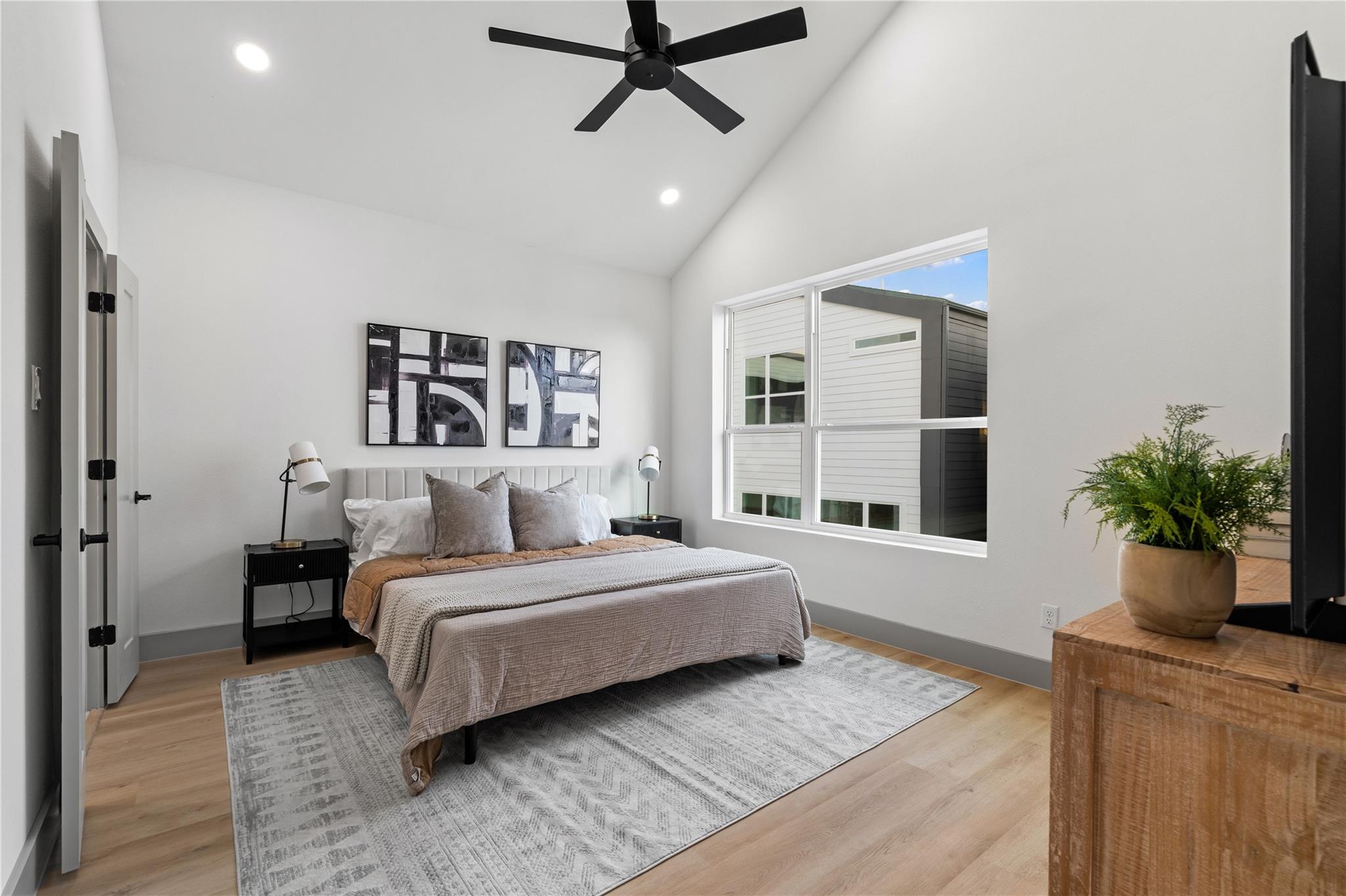 Framed by vaulted ceilings and wide-plank flooring, the primary suite flows seamlessly into a spa-inspired bath through double doors—offering both comfort and convenience in a refined, retreat-like setting. A perfect blend of privacy and polish.