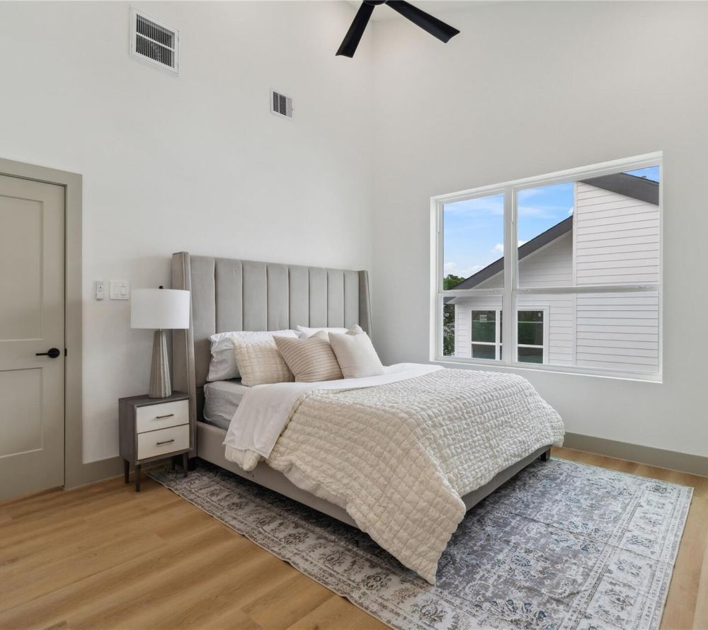 Vaulted ceilings with a modern fan overhead add volume and airiness, enhancing the sense of space and stillness.