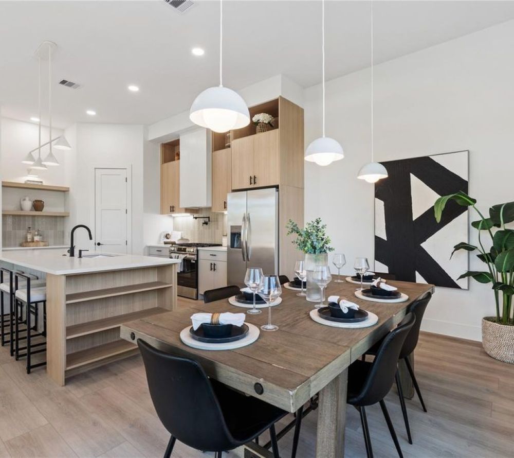 Thoughtfully designed with clean lines and elevated finishes, this kitchen-dining combo features custom flat-panel cabinetry, soft-close drawers, quartz countertops, and a spacious island with waterfall detail—bathed in natural light from oversized energy-efficient windows.